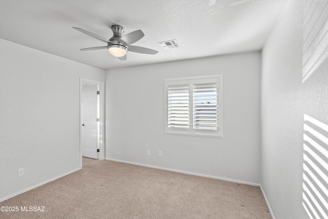 carpeted empty room featuring ceiling fan and a textured ceiling