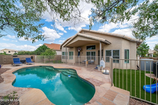 view of swimming pool featuring central air condition unit, a patio area, and a yard