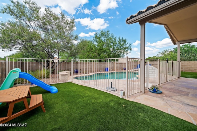 view of pool with a patio area and a lawn