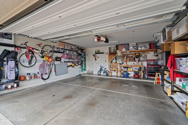 garage featuring a garage door opener and a workshop area