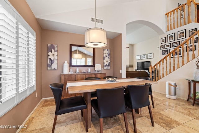 dining area featuring a healthy amount of sunlight and high vaulted ceiling