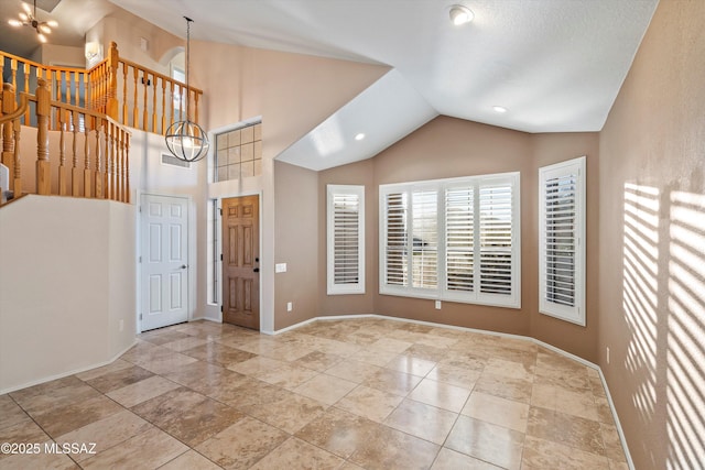 foyer entrance featuring vaulted ceiling and an inviting chandelier