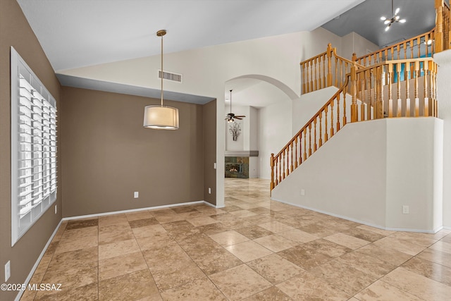 9797 E Holden Pl, Tucson, AZ 85748 - spare room with ceiling fan, arched walkways, stairway, high vaulted ceiling, and healthy amount of natural light