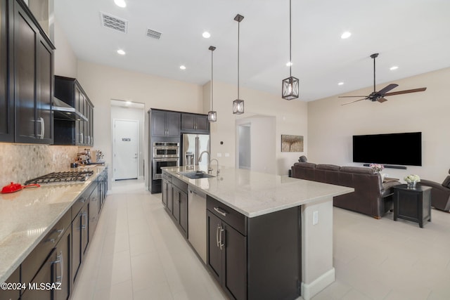 kitchen with pendant lighting, a large island with sink, sink, appliances with stainless steel finishes, and ceiling fan