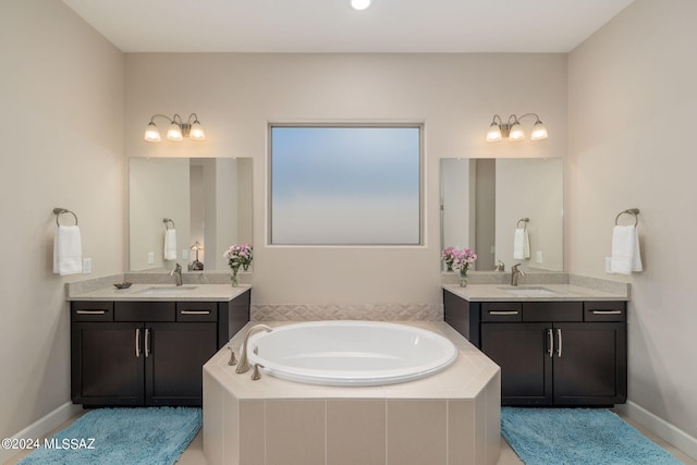 bathroom featuring tiled tub and vanity