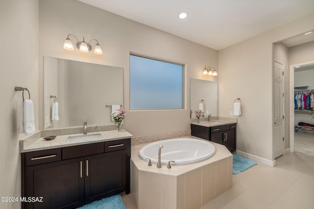 bathroom featuring tiled tub, vanity, and tile patterned floors