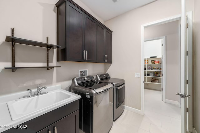 clothes washing area with cabinets, sink, washer and dryer, and light tile patterned flooring