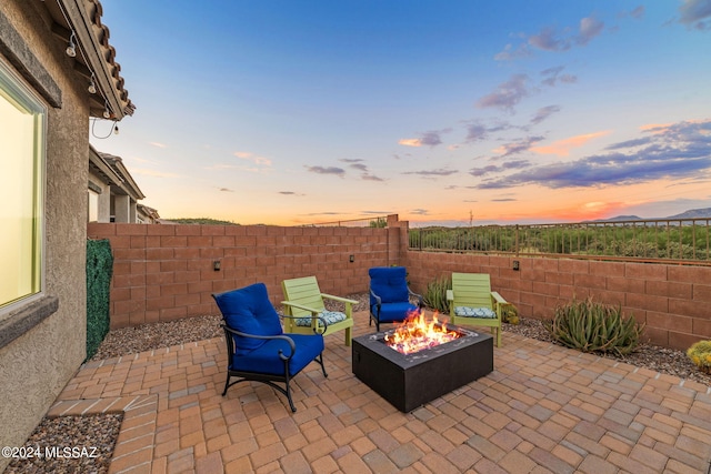 patio terrace at dusk featuring an outdoor fire pit