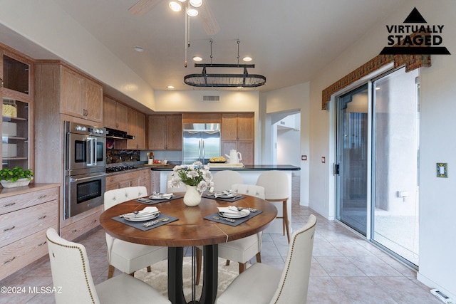 tiled dining area featuring ceiling fan with notable chandelier