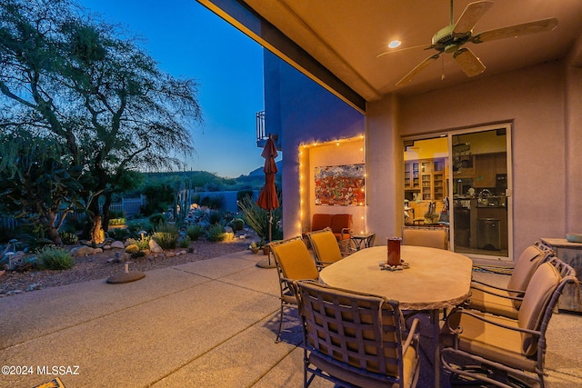 patio terrace at dusk featuring ceiling fan