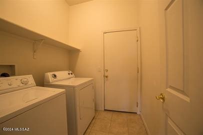 laundry area with separate washer and dryer and light tile patterned flooring