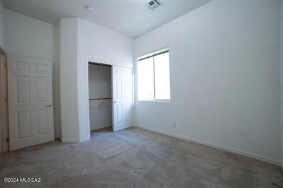 unfurnished bedroom featuring light carpet and a closet