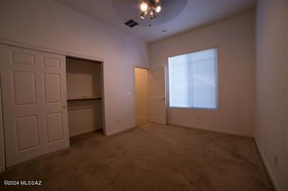 unfurnished bedroom featuring a closet, ceiling fan, and carpet floors