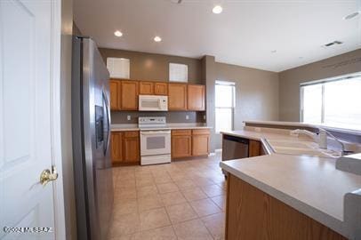 kitchen with sink, stainless steel appliances, and light tile patterned flooring