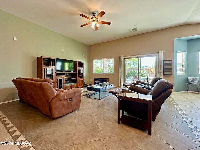 tiled living room featuring ceiling fan and vaulted ceiling