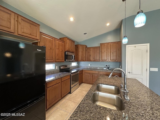 kitchen with brown cabinets, stainless steel appliances, hanging light fixtures, a sink, and dark stone countertops