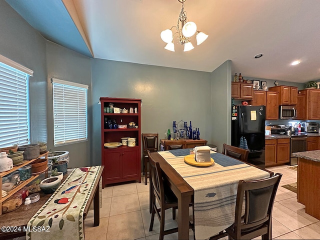 dining area with light tile patterned floors and an inviting chandelier