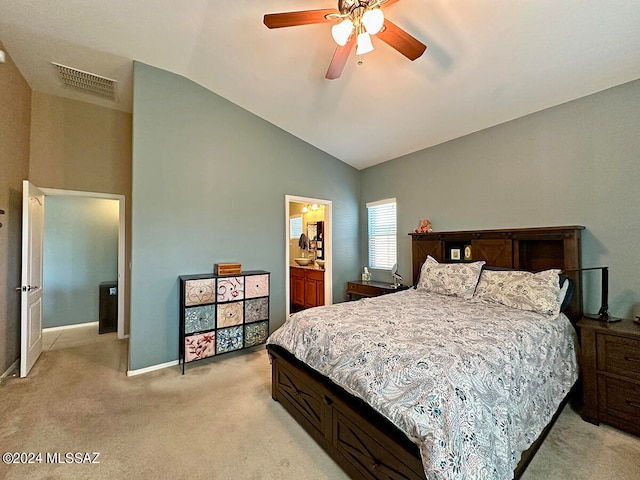 bedroom featuring connected bathroom, vaulted ceiling, light carpet, and ceiling fan