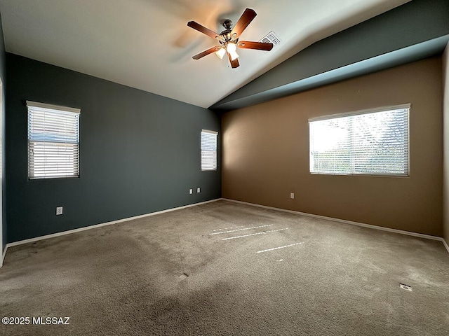 carpeted spare room with vaulted ceiling, plenty of natural light, and visible vents