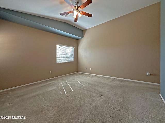 carpeted empty room featuring lofted ceiling, ceiling fan, visible vents, and baseboards