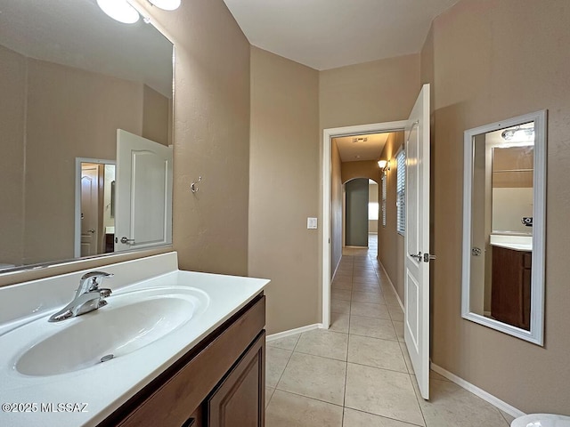 bathroom with baseboards, vanity, and tile patterned floors