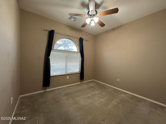 carpeted spare room with visible vents, ceiling fan, and baseboards