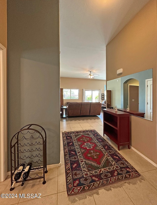 interior space with arched walkways, light tile patterned flooring, and baseboards