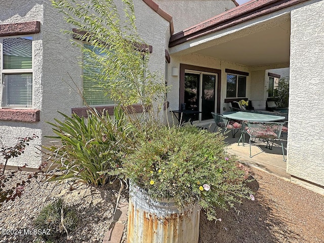 exterior space featuring outdoor dining area, a patio, and stucco siding