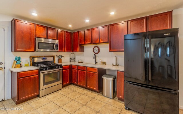 kitchen with sink, appliances with stainless steel finishes, and light tile patterned flooring