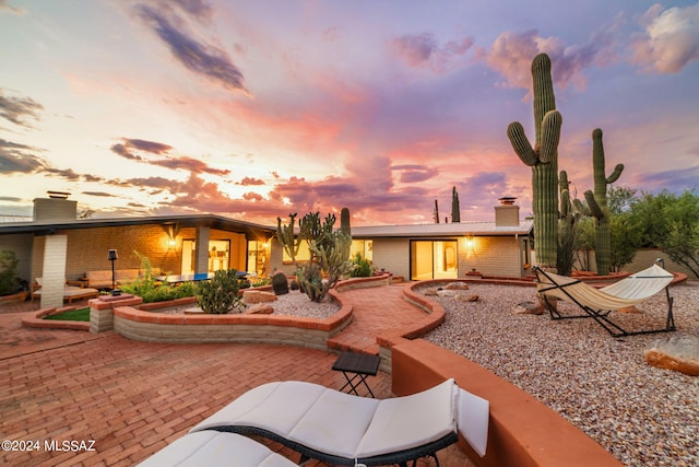 back house at dusk with a patio