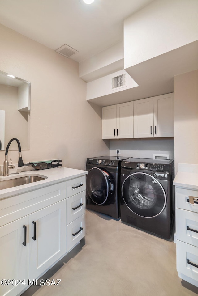 laundry area featuring cabinets, washing machine and clothes dryer, and sink