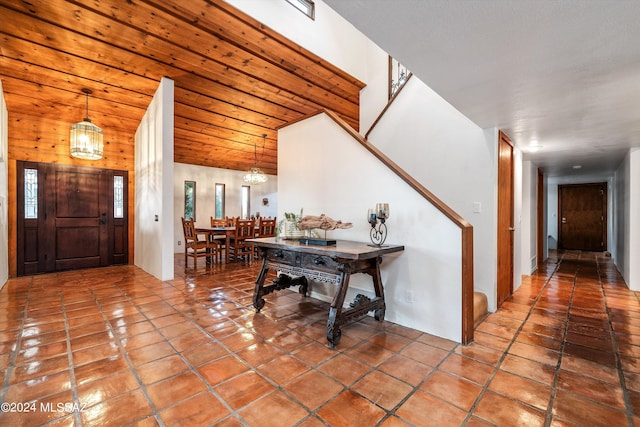 tiled entryway with a notable chandelier