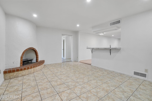 unfurnished living room featuring light tile patterned floors and a fireplace