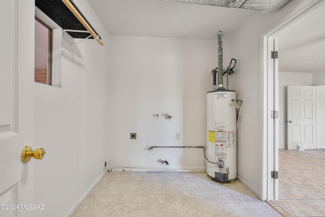 interior space featuring a textured ceiling, gas water heater, electric dryer hookup, washer hookup, and light tile patterned flooring