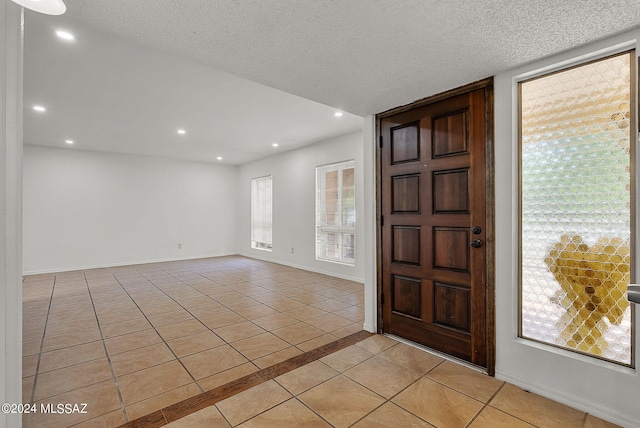 foyer entrance featuring light tile patterned floors and a textured ceiling