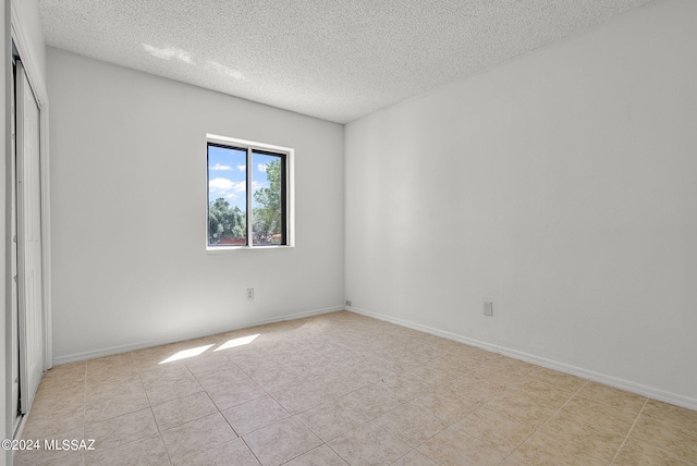 unfurnished room with a textured ceiling