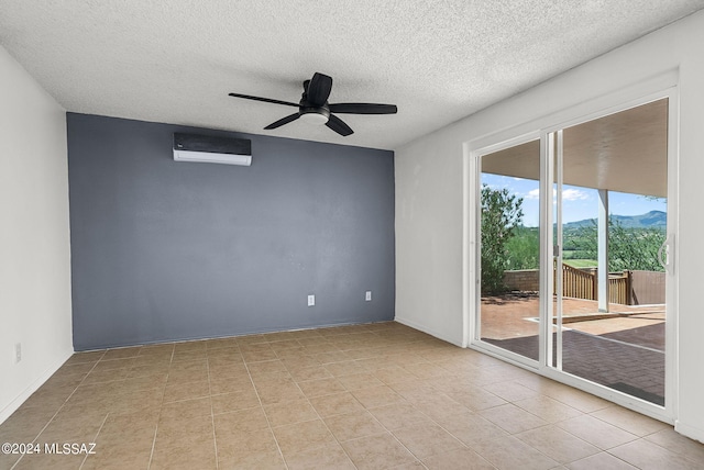 tiled empty room with a textured ceiling, a wall mounted air conditioner, and ceiling fan