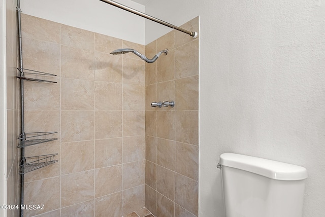 bathroom with toilet and a tile shower