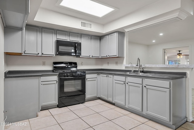 kitchen with light tile patterned floors, sink, gray cabinets, black appliances, and ceiling fan