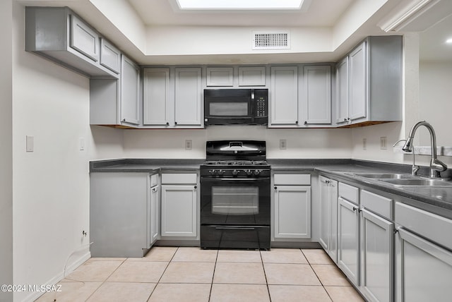 kitchen featuring black appliances, gray cabinetry, light tile patterned floors, and sink