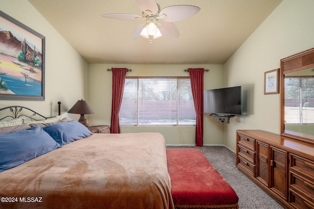 bedroom with multiple windows, ceiling fan, vaulted ceiling, and light colored carpet