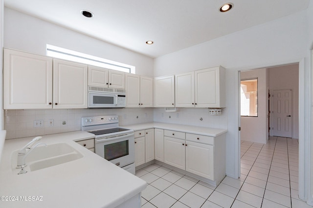 kitchen with white cabinetry, white appliances, tasteful backsplash, light tile patterned floors, and sink