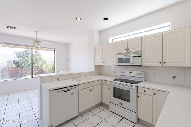 kitchen with white appliances, kitchen peninsula, sink, ceiling fan, and white cabinets