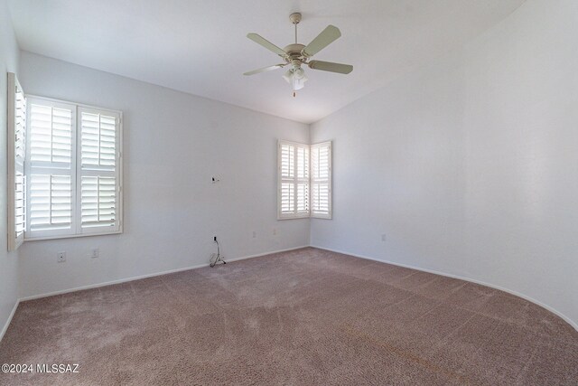 spare room featuring vaulted ceiling, ceiling fan, and carpet