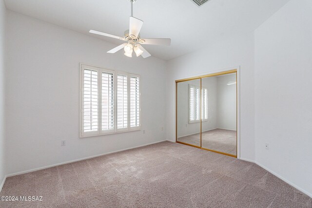 unfurnished bedroom featuring light carpet, ceiling fan, and a closet