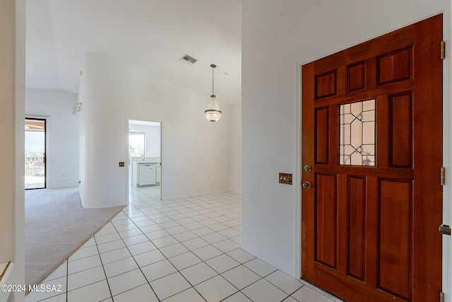 carpeted entrance foyer featuring lofted ceiling