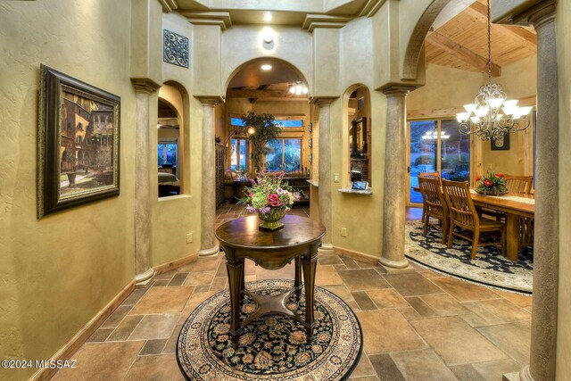 hallway with sink, a high ceiling, and ornate columns