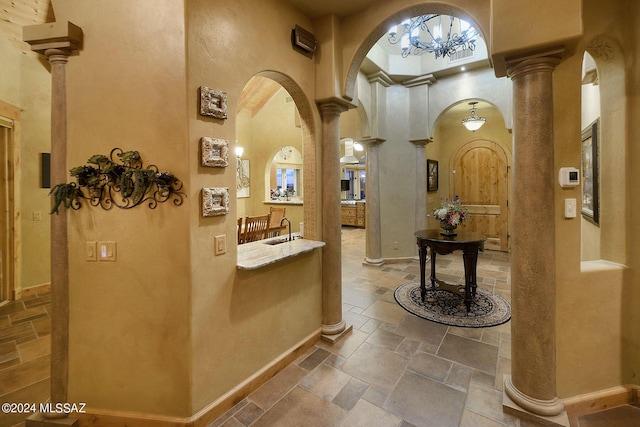 interior space with decorative columns, arched walkways, and stone tile flooring