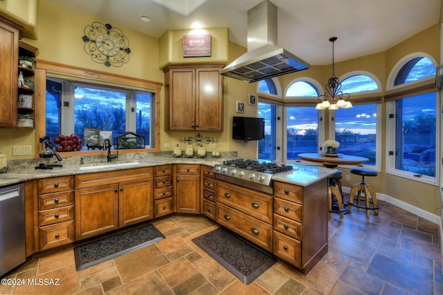 kitchen with sink, appliances with stainless steel finishes, island range hood, decorative light fixtures, and kitchen peninsula