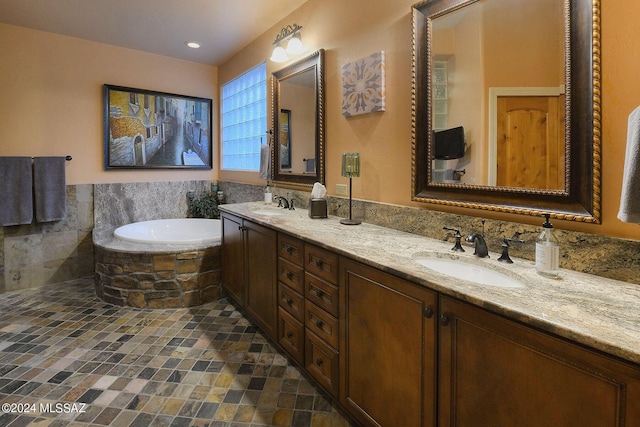 bathroom featuring a relaxing tiled tub and vanity